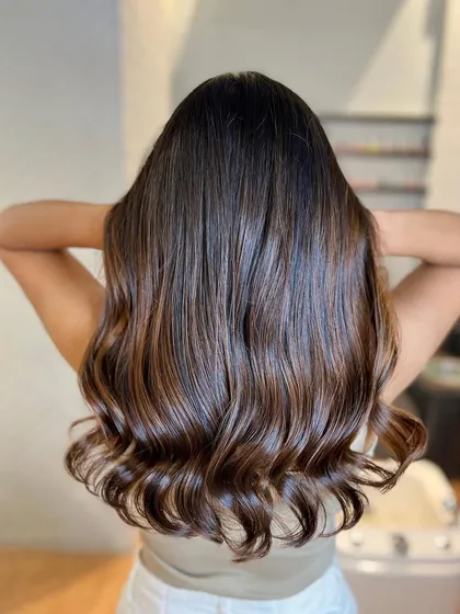 This chocolate brown balayage is rich and luxurious. It's a timeless look that adds incredible shine and dimension to dark hair.