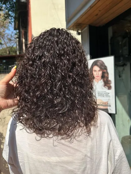 A close-up of the soft, defined curls from our perming service. This shows the consistency and health of the hair, proving that you can have curls without compromising on hair quality.