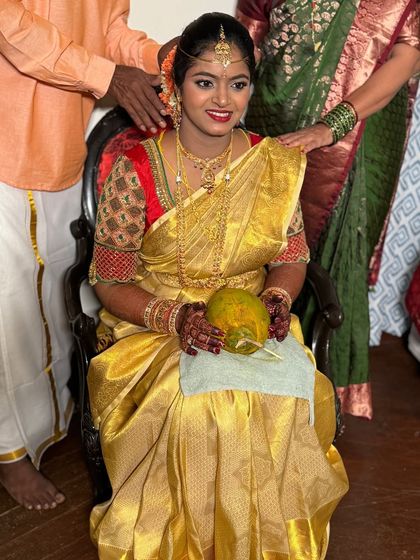 Seated for the ceremony, this bride looks absolutely divine. Her traditional attire and the ritualistic elements, like the coconut, are all part of the beautiful wedding story.