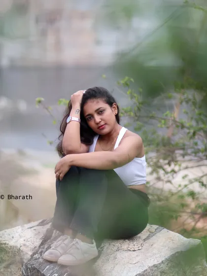 A seated portrait on a rock, with a blurred background that keeps the focus on the model.