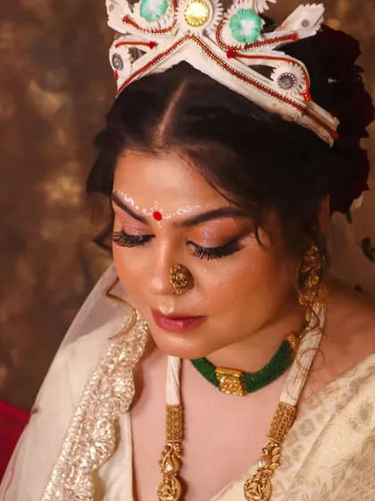 A close-up of this bride's soft, ethereal Bengali makeup. The focus is on luminous skin and beautifully defined eyes, ensuring she looks like herself at her most beautiful.
