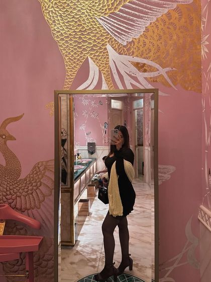 A mirror selfie in a beautifully decorated pink washroom, showing off the party look.
