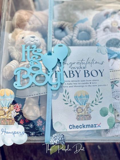 A sweet "It's a Boy!" hamper to welcome a new arrival. This gift, presented in a clear acrylic box, includes a soft lion toy, baby booties, and a personalized congratulatory card.