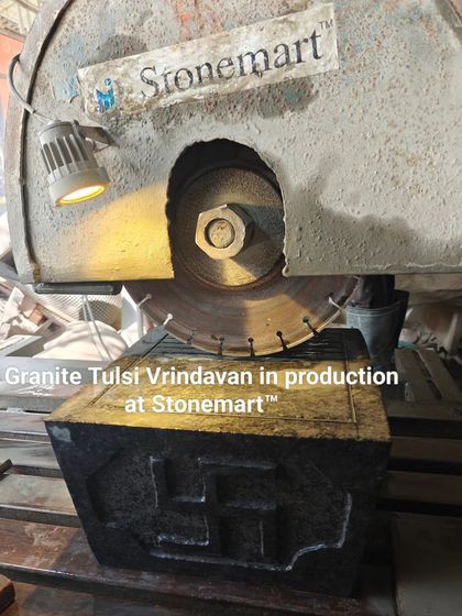 A granite Tulsi Vrindavan in production at our workshop. The large cutting wheel in the background shows the heavy machinery we use to handle large stone blocks.