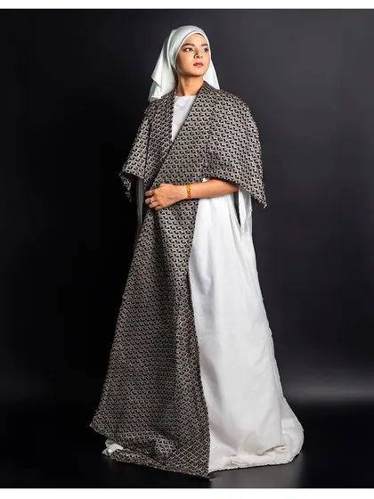 This three-quarter shot shows how the patterned overcoat layers with the white dress beneath. It’s a great way to display the versatility and styling of a designer's collection.