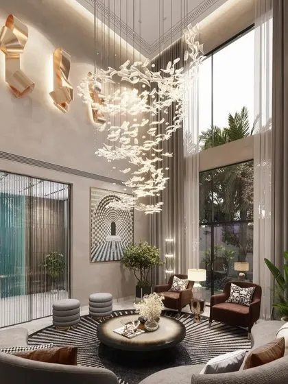 We bring nature indoors as an element of luxury in this double-height drawing room. A magnificent chandelier mimics a flock of birds in flight, complemented by large windows that flood the space with natural light, creating a seamless connection between the opulent interior and the lush exterior.