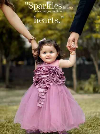 The soul is healed by being with children. A beautiful outdoor portrait of a little girl holding her parents' hands as she takes her first steps.