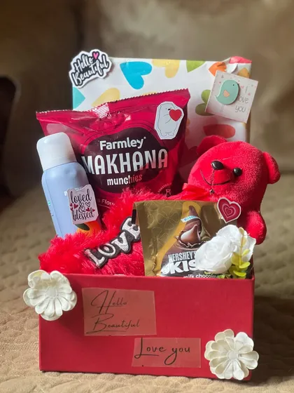 A classic romantic gesture in a box. This hamper is curated with love, featuring a bright red theme, a soft teddy bear, Hershey's Kisses, and other treats to say "I love you" in the sweetest way possible.