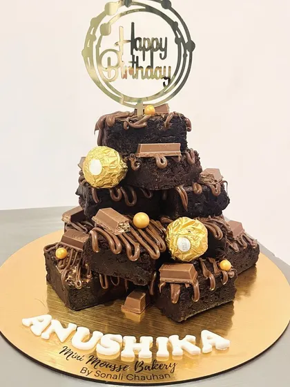 For those who think a brownie is better than cake, I present the brownie tower. This is a stack of my fudgiest, gooiest eggless brownies, drizzled with chocolate and topped with Ferrero Rocher and KitKat. It's pure indulgence.