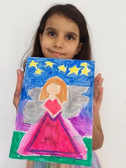 This student's angel is set against a starry night sky, using a mix of pastels and paint to create a magical scene.