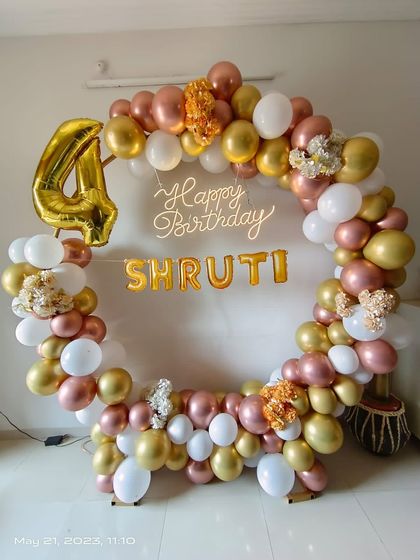 A beautiful rose gold, white, and gold balloon ring for Shruti's 4th birthday, complete with a neon sign and foil number balloon.