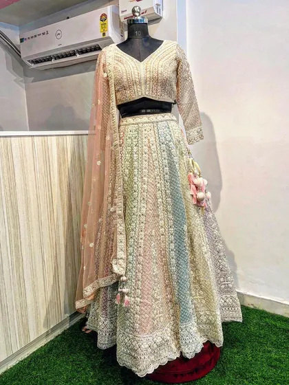 This pastel rainbow lehenga is a beautiful choice for a day wedding or engagement. It features delicate full-sleeve embroidery, mirror work, and a soft, multi-tonal skirt, complete with charming tassels for a touch of playfulness.