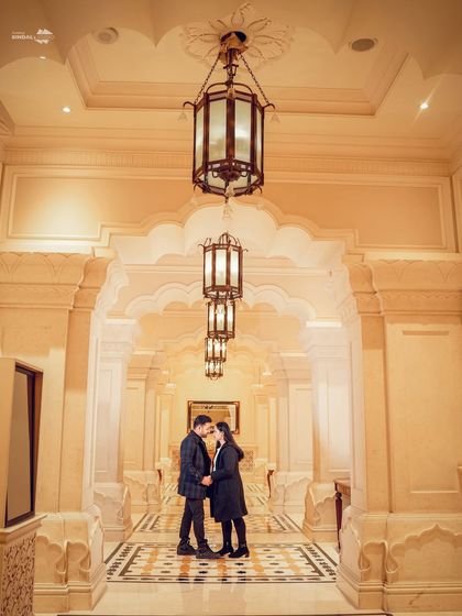 A stunning shot down a long, arched hallway, using leading lines and warm lighting to create a sense of grandeur and intimacy. The couple's silhouette adds a touch of romance.