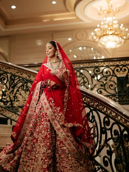 Descending the stairs like royalty. This shot captures the grandeur of Sona's bridal look, with makeup designed to look flawless from every angle and in every light.