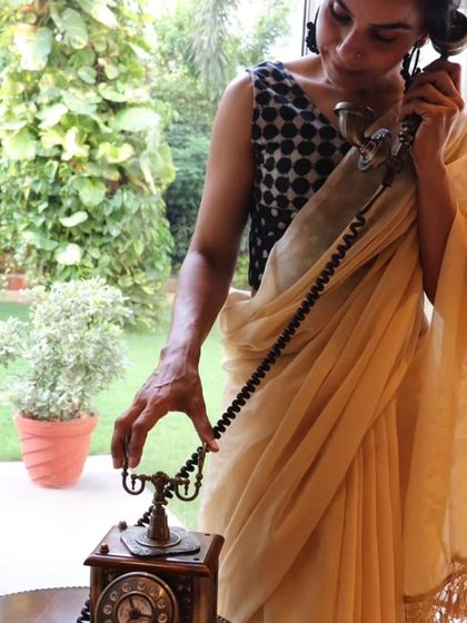 A vintage-inspired shot of a woman in a classic sari and a polka-dotted blouse, showcasing timeless style.