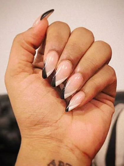 A sharp and edgy look with a pointed stiletto shape and a graphic black and white V-shaped French tip.
