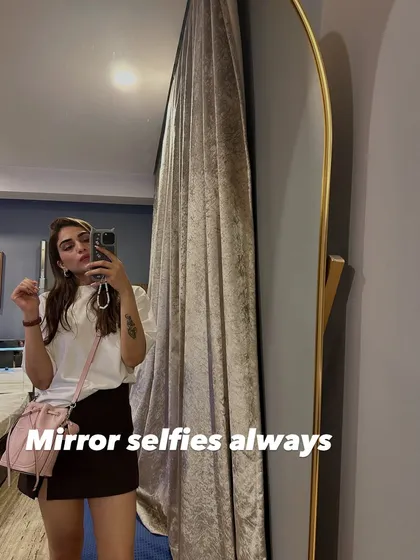 A mirror selfie showing a classic black skirt and white top combination. It's a timeless look that works for so many different occasions.