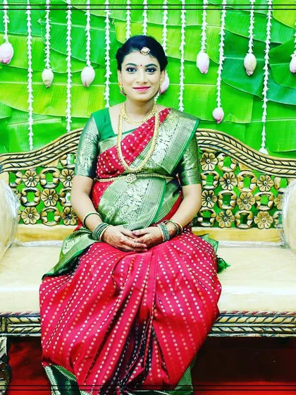 A beautiful portrait of a mother-to-be at her baby shower. The backdrop of green banana leaves and white floral strings provides a fresh and traditional setting.