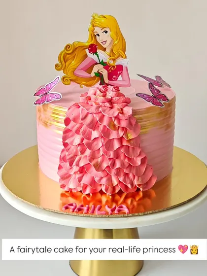 A fairytale cake for a real-life princess. This design features Princess Aurora with a beautiful gown made of piped whipped cream petals.