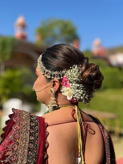 The charm of a floral wedding bun is unbeatable. This side-swept bun is adorned with baby's breath and pink flowers, creating a soft and romantic look.