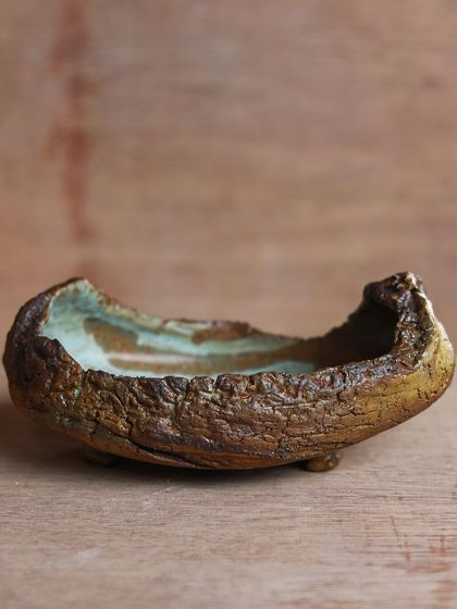 A boat shaped tray with a textured exterior and a soft, flowing glaze inside, a piece born from a workshop focused on surface variation.