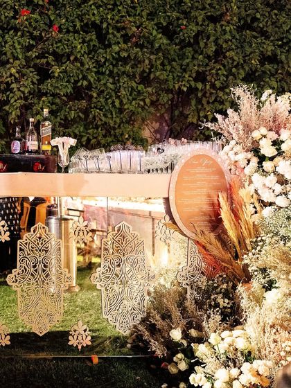The bar front was decorated with intricate gold Hamsa cutouts and surrounded by clouds of white flowers.