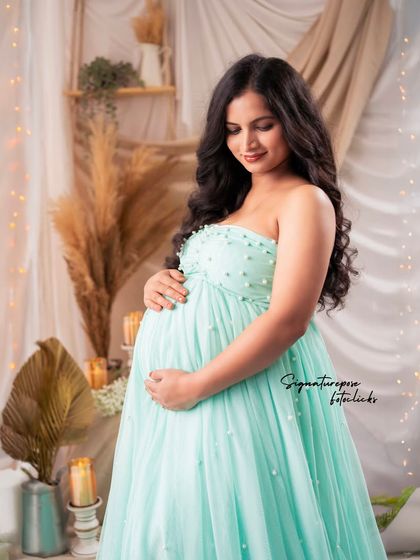 A close-up focusing on the mother's gentle expression and the soft lighting of the boho studio setup.