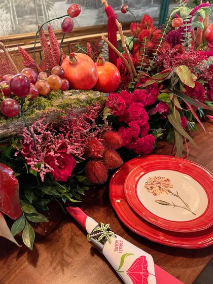 A close-up of the table decor, highlighting the beautiful textures of the flowers, fruits, and custom plates.