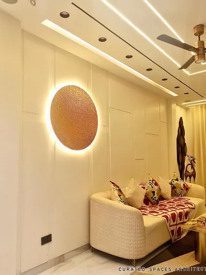 Lighting is key to setting the mood. This backlit circular art piece acts as a modern focal point on the paneled wall, adding a warm and artistic glow to the living room.