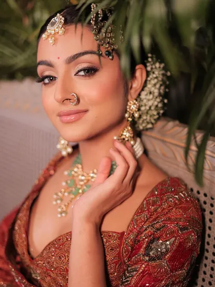 A close-up of a classic look with a modern twist. The makeup is soft and glowing, with a beautiful floral hair accessory.