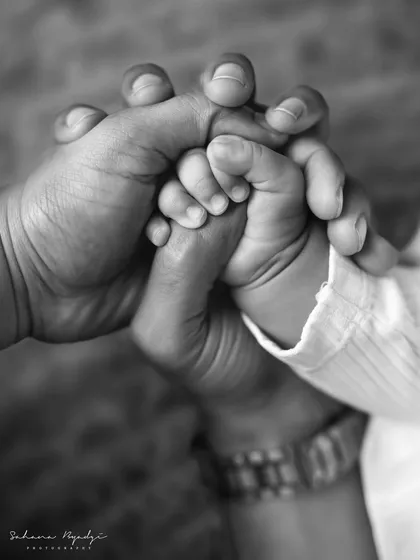 A black and white close-up of a family's hands held together. A powerful symbol of unity and love.