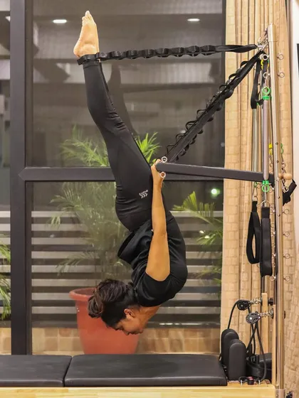 This full inversion on the Cadillac, known as hanging back, is a powerful way to decompress the spine, improve circulation, and build incredible upper body and core strength.