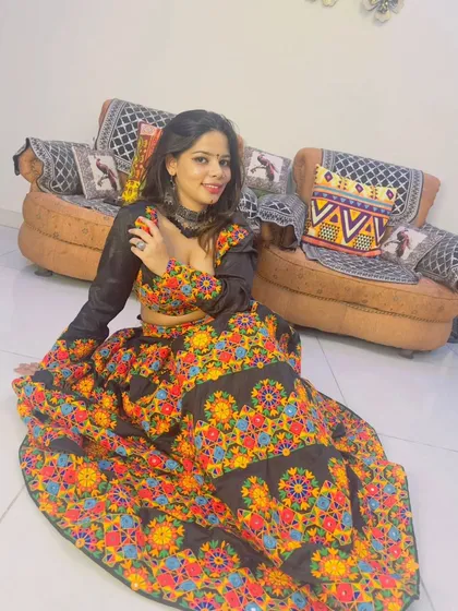 A client looking gorgeous in a black lehenga with vibrant floral embroidery, a perfect choice for a Navratri celebration.