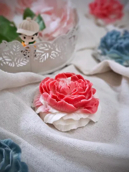 A close-up of my Scented Peony Candle. The delicate petals are hand-poured, and it comes in two irresistible fragrance options: Rose Blossom and Enchantment.