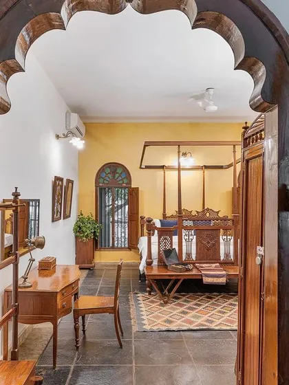 A view into the Arundati suite through its grand, arched wooden doorway, giving a glimpse of the classic elegance that lies within.