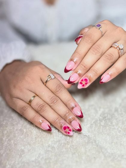 A variation of the maroon floral design, this time on a French tip base. This shows how a single art concept can be adapted into different styles.