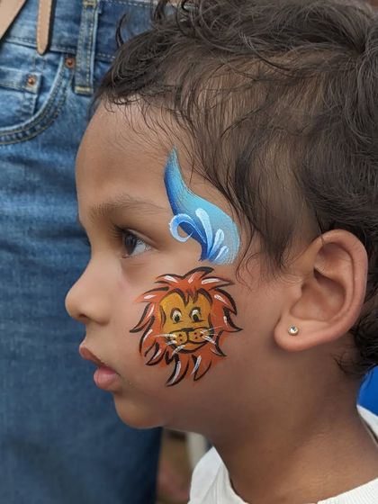 Another angle of the cute lion cub face paint, a popular choice for boys and girls alike.