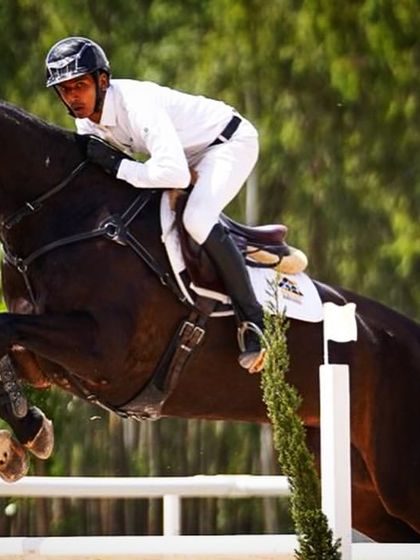 A close-up action shot of Ashish Limaye and Jinx, a horse bred at my school, during their winning Grand Prix performance. The focus and determination are palpable.