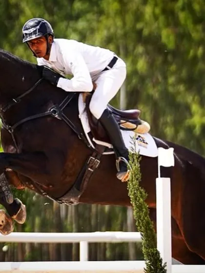 A powerful action shot of Ashish Limaye and Jinx mid-flight. This image captures the athleticism and focus required for top level show jumping.
