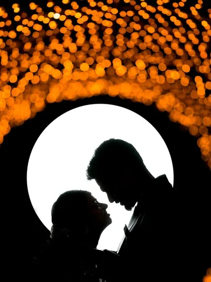 We love playing with light to create unique, artistic shots. This silhouette portrait uses a tunnel of lights to frame the couple, turning a simple pose into a dramatic and memorable image of their connection.