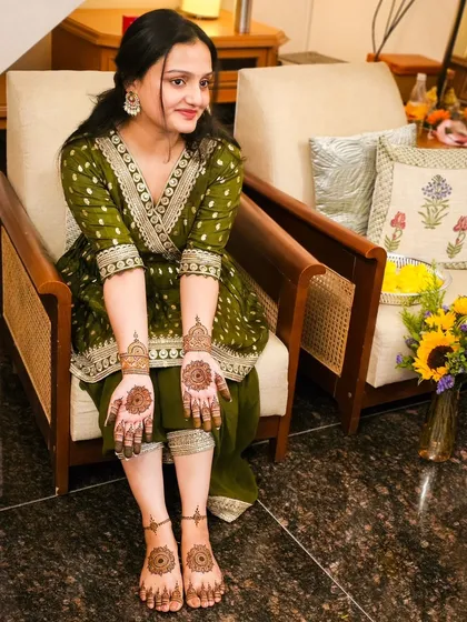 A full view of the bride with her minimal hand and feet henna, looking elegant and happy.