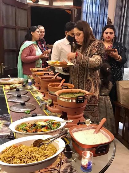 Guests enjoying the rustic, home-style buffet at a Lohri party. The terracotta serveware added a unique charm to the dining experience.