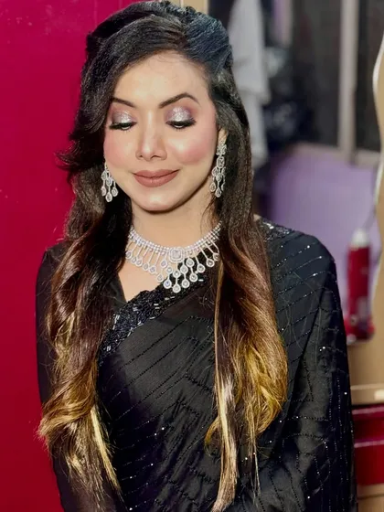 A classic soft glam look with silver glitter eyeshadow and a nude lip, paired with a timeless black saree.