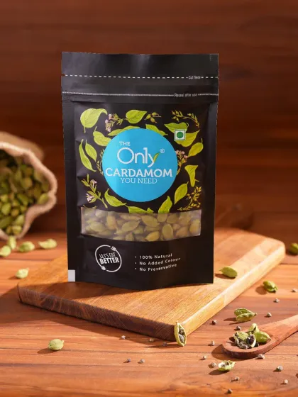 A moody, rustic shot of cardamom packaging on a wooden board. We use lighting and natural props to create an atmosphere that matches the product's essence.