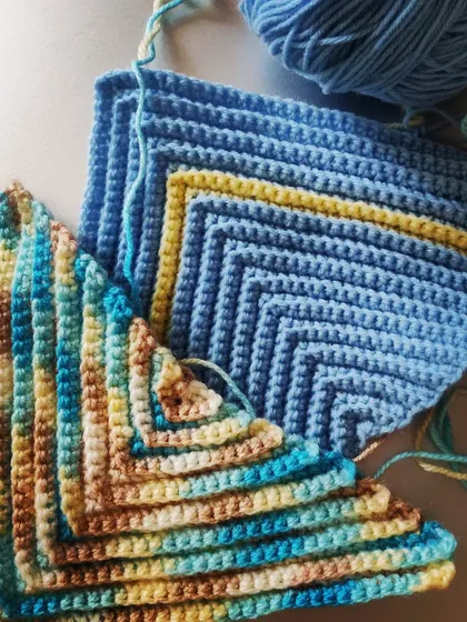 A work in progress. These beautiful blue and multi-colored pieces are being created with a simple stitch that results in a lovely diagonal striped pattern.