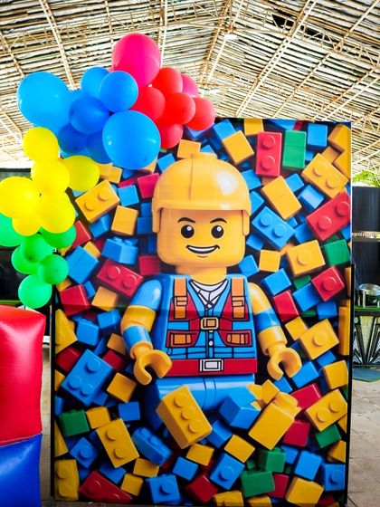 A LEGO character photo booth where guests can pose as if they are bursting out of a pile of bricks.
