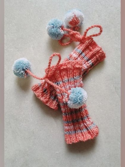 A closer look at the knitted leg warmers with their cute pom-pom ties. They are adjustable and super cozy.