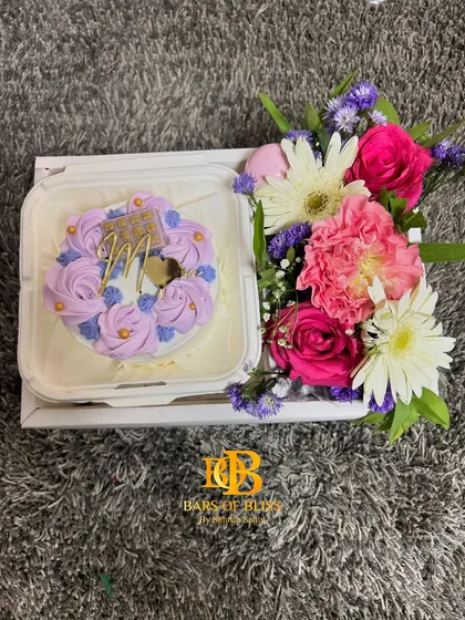 A "Best Mom" hamper with a floral-topped bento cake and a fresh bouquet of mixed flowers.
