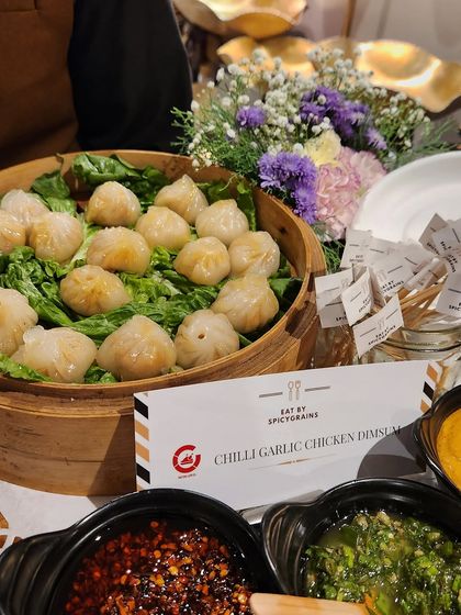 Our Chilli Garlic Chicken Dimsums are juicy, flavourful, and served steaming hot from a traditional bamboo basket, accompanied by a variety of spicy dipping sauces.