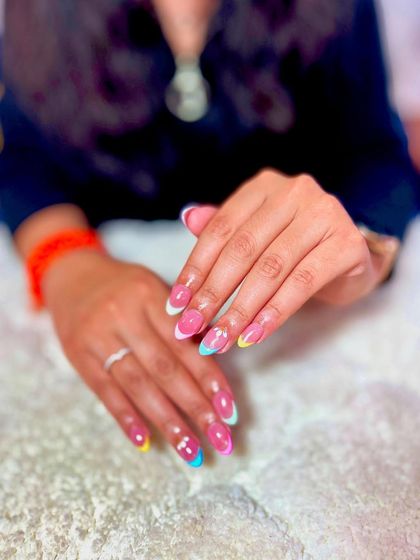 A fun and colorful French manicure with pastel rainbow tips. This is a great way to add a playful twist to a classic design.